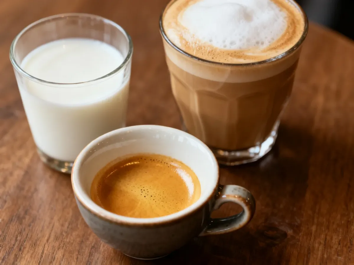 Filiżanka czystego espresso obok mleka i kawy mlecznej