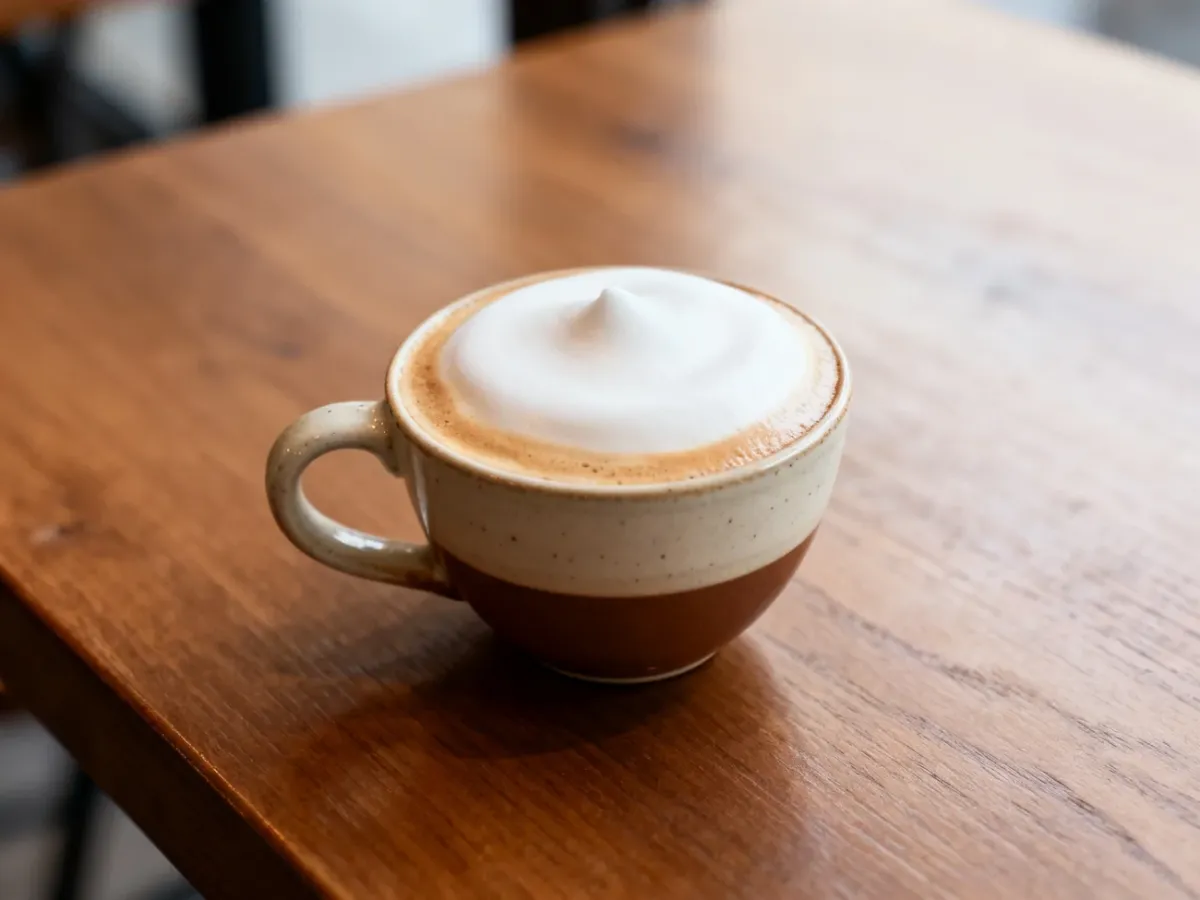 Klasyczne cappuccino z gęstą, kremową mikropianką w małej filiżance